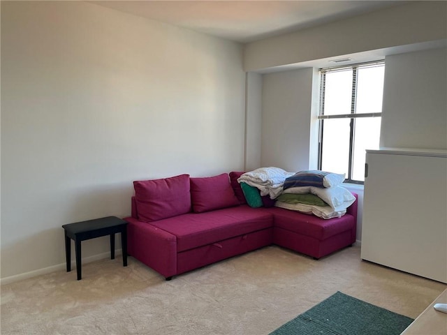 living area with light carpet and baseboards