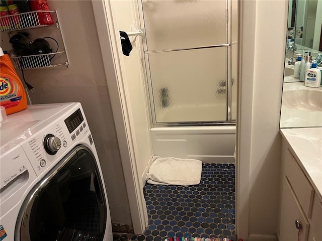 clothes washing area with laundry area, a sink, and washer / dryer