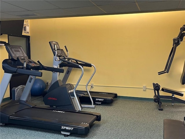 workout room featuring a drop ceiling and baseboards