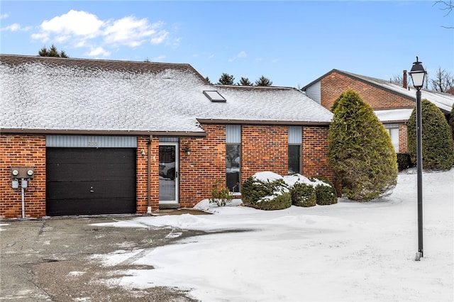 view of front of house with a garage, brick siding, and roof with shingles