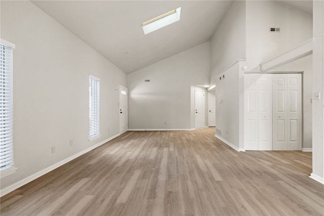 unfurnished living room featuring baseboards, high vaulted ceiling, visible vents, and light wood-style floors