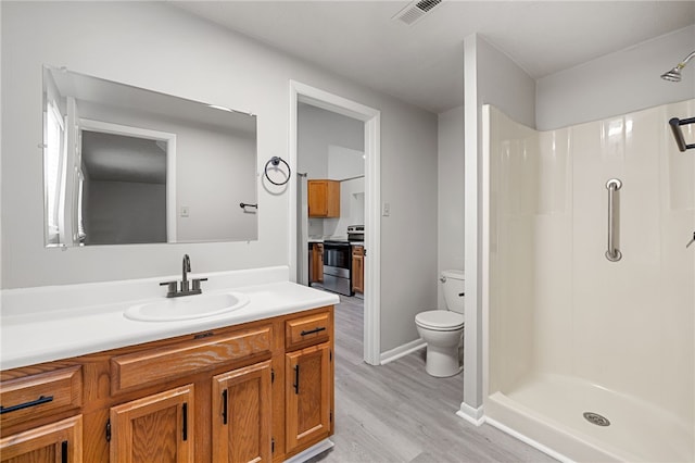 bathroom featuring toilet, a stall shower, visible vents, and vanity