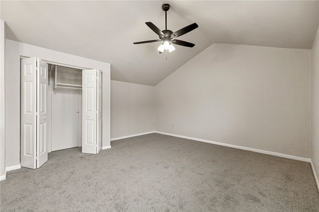 unfurnished bedroom with carpet floors, a closet, vaulted ceiling, and baseboards