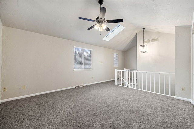 bonus room with lofted ceiling with skylight, dark carpet, visible vents, and baseboards