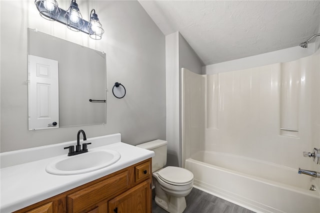 full bathroom featuring shower / washtub combination, toilet, a textured ceiling, vanity, and wood finished floors