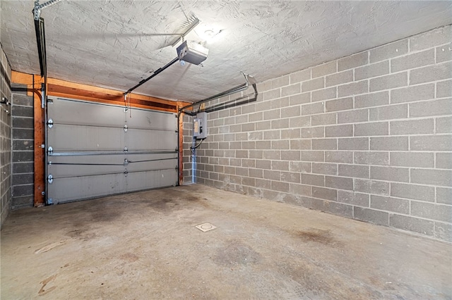 garage with concrete block wall and a garage door opener