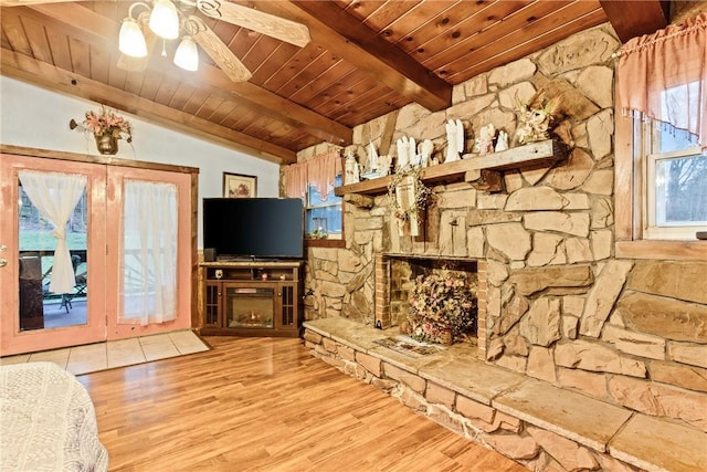 unfurnished living room featuring lofted ceiling with beams, a fireplace, wooden ceiling, and light wood-style floors