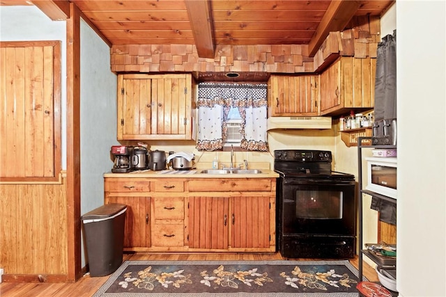 kitchen with under cabinet range hood, electric range, a sink, light countertops, and beamed ceiling