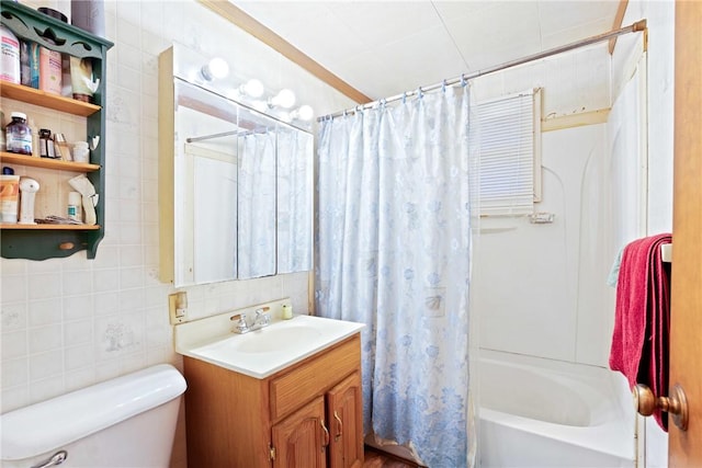 bathroom featuring toilet, shower / bath combination with curtain, vanity, and tile walls