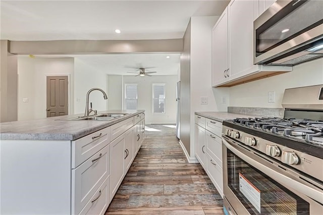 kitchen with an island with sink, white cabinetry, appliances with stainless steel finishes, and a sink