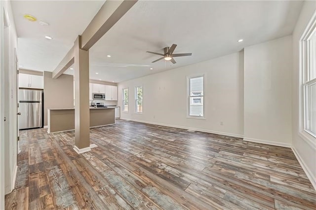 unfurnished living room featuring a ceiling fan, recessed lighting, baseboards, and wood finished floors