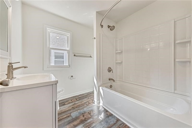 full bath with baseboards, toilet, shower / tub combination, wood finished floors, and vanity