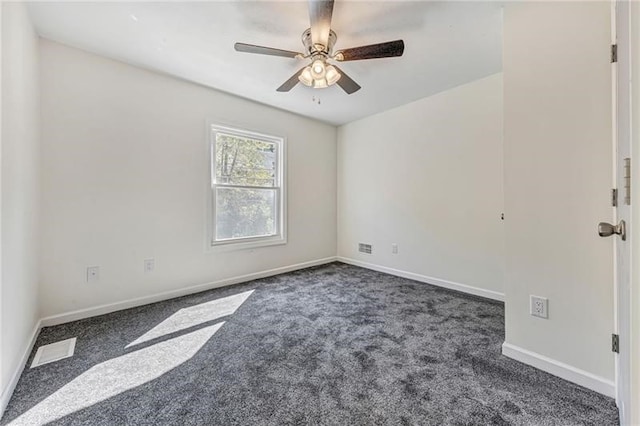 spare room with a ceiling fan, dark carpet, visible vents, and baseboards