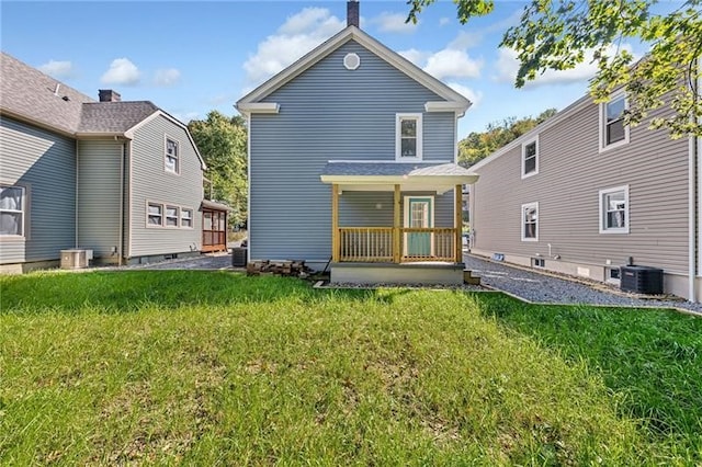 back of property with a lawn and central air condition unit