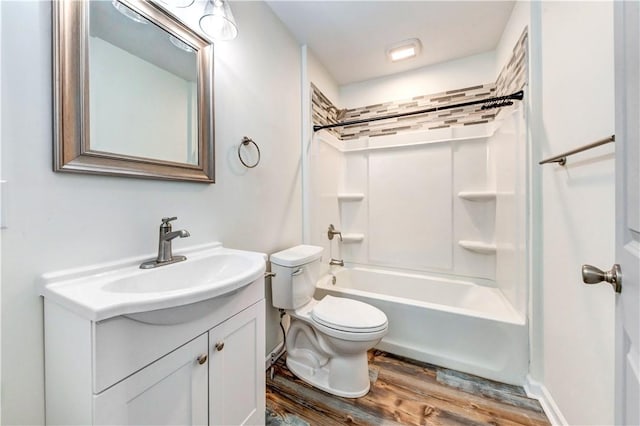 bathroom featuring toilet, bathing tub / shower combination, wood finished floors, and vanity