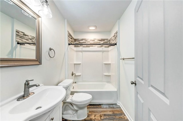 bathroom featuring toilet, shower / washtub combination, wood finished floors, and vanity