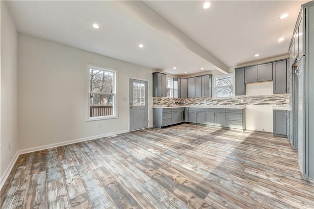 kitchen featuring gray cabinets, light countertops, and backsplash