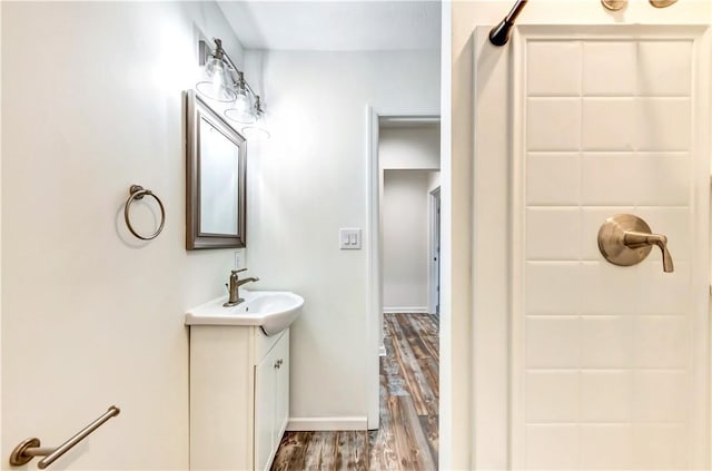 full bath with vanity, baseboards, and wood finished floors