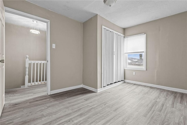 1155 6th Ave, Freedom, PA 15042 - unfurnished bedroom featuring light wood-type flooring, a closet, baseboards, and a textured ceiling