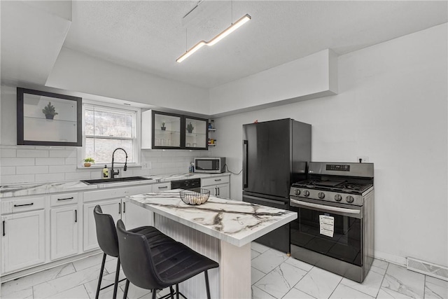 1155 6th Ave, Freedom, PA 15042 - kitchen featuring a kitchen island, marble finish floor, a sink, and appliances with stainless steel finishes