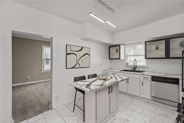 1155 6th Ave, Freedom, PA 15042 - kitchen with a sink, light countertops, a kitchen bar, stainless steel dishwasher, and marble finish floor
