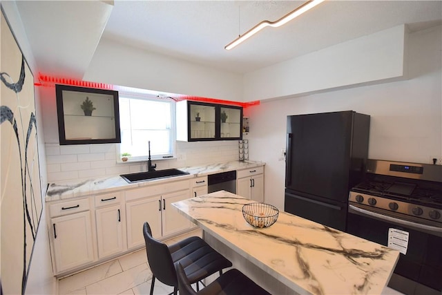 1155 6th Ave, Freedom, PA 15042 - kitchen with light stone counters, freestanding refrigerator, dishwasher, stainless steel range with gas stovetop, and a sink