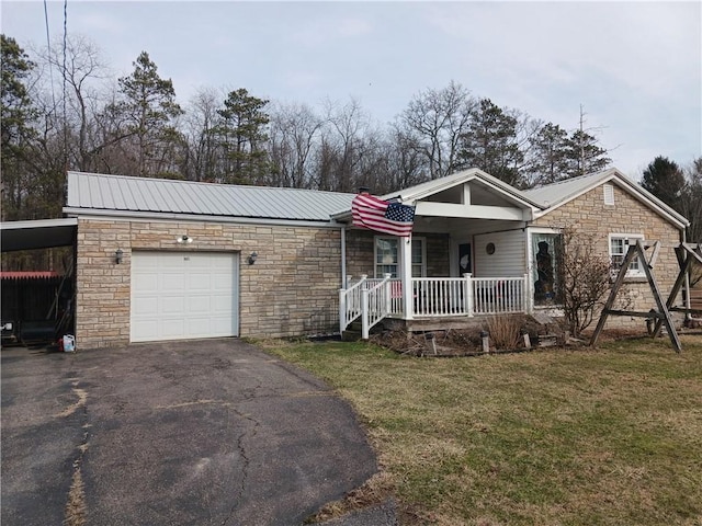 single story home with a garage, metal roof, a front lawn, and covered porch