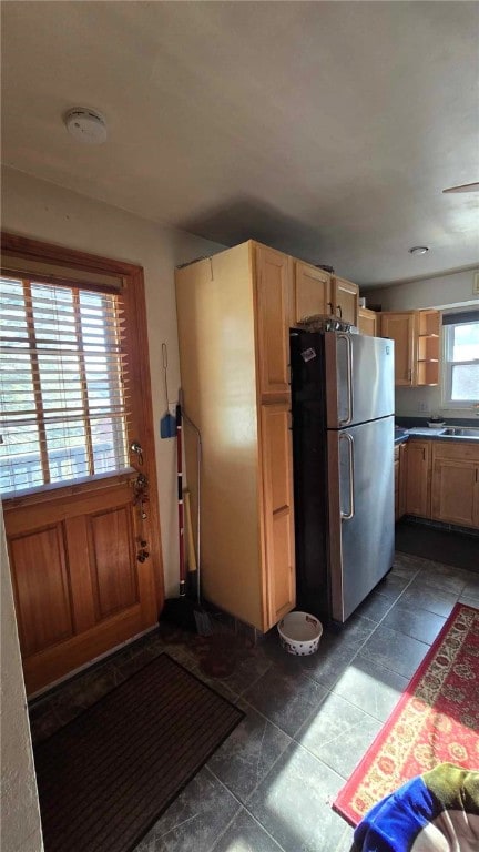 kitchen featuring open shelves, a sink, and freestanding refrigerator