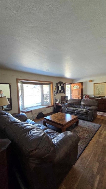 living area with a textured ceiling and wood finished floors