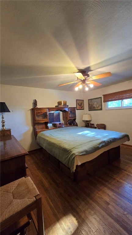 bedroom with ceiling fan, dark wood-style flooring, and pool table