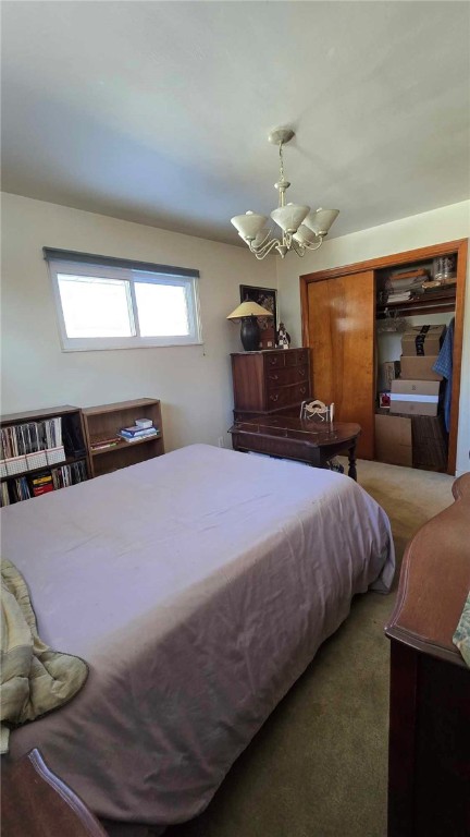 bedroom with dark carpet and an inviting chandelier