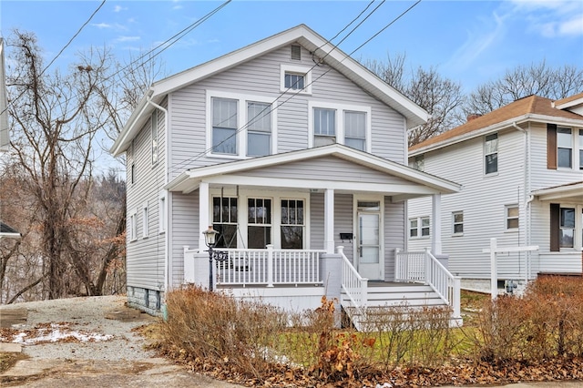 american foursquare style home featuring covered porch