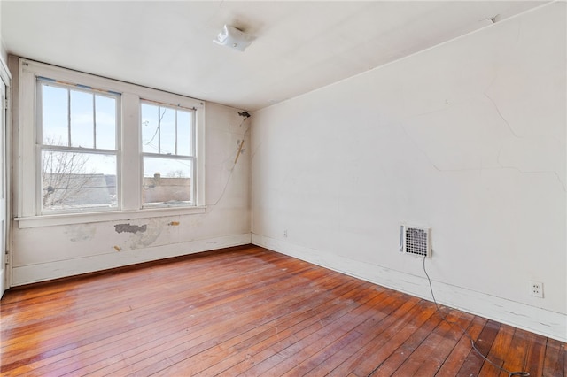 spare room featuring light wood-style flooring, visible vents, and baseboards