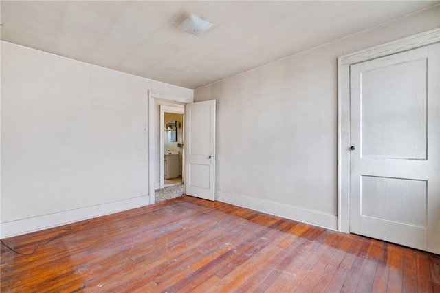 empty room with baseboards and wood finished floors