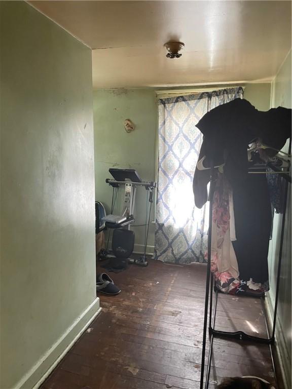 workout room with baseboards and wood finished floors