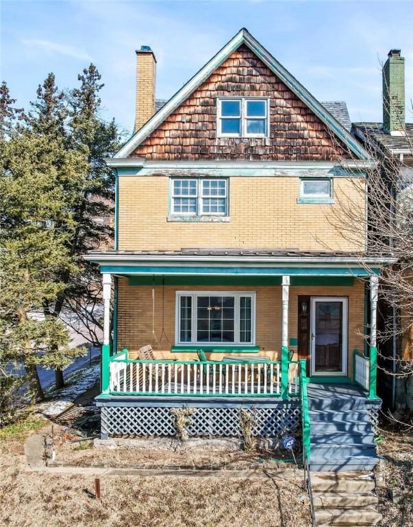 view of front of house featuring a porch and a chimney