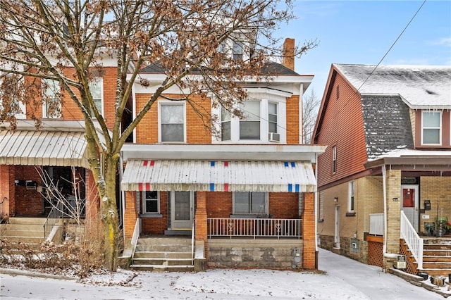 view of front of home with covered porch and brick siding