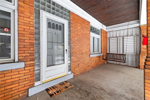 view of exterior entry featuring brick siding