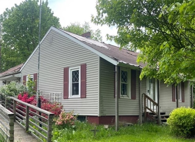 view of home's exterior with entry steps and a chimney