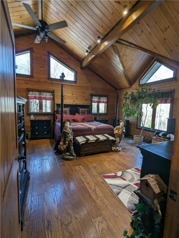 bedroom featuring dark wood-style floors, wood walls, and lofted ceiling with beams