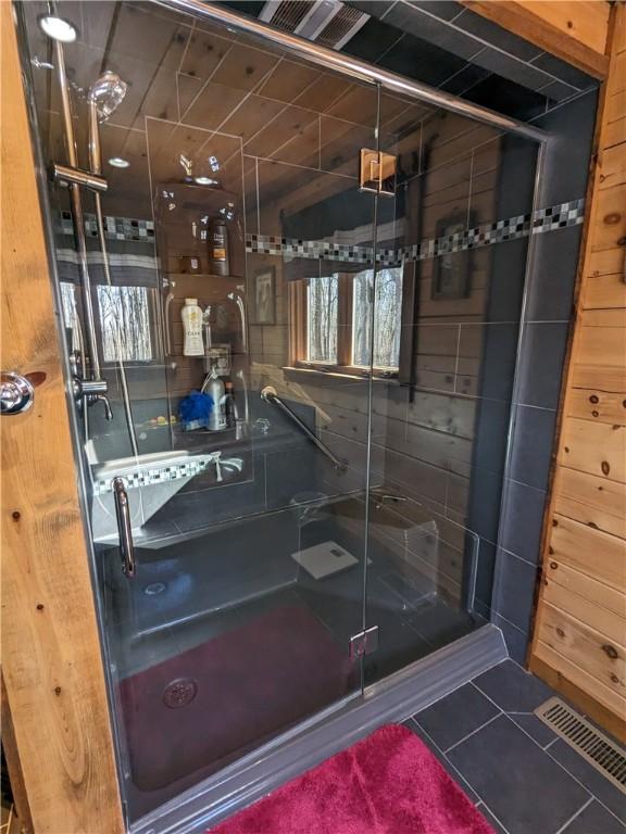 bathroom with tiled shower, tile patterned flooring, and visible vents