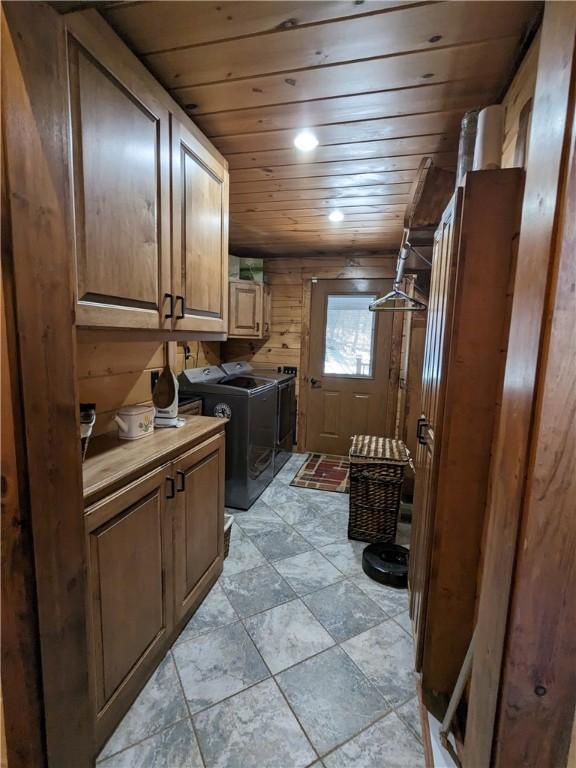 washroom with cabinet space, wood ceiling, and separate washer and dryer