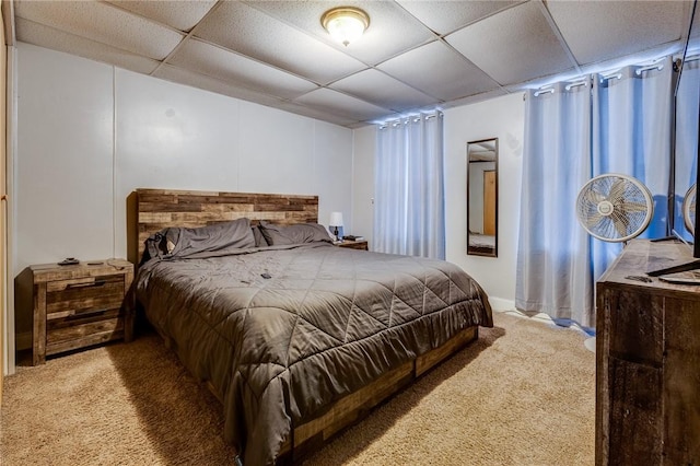 bedroom with carpet flooring and a paneled ceiling