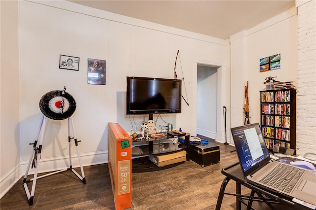 office space with baseboards, brick wall, and wood finished floors