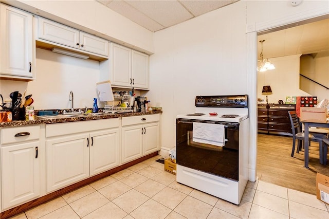 kitchen featuring pendant lighting, white cabinetry, range with electric stovetop, and light tile patterned floors