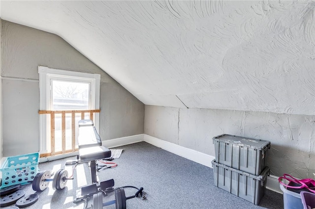 workout area featuring lofted ceiling, baseboards, a textured ceiling, and carpet flooring