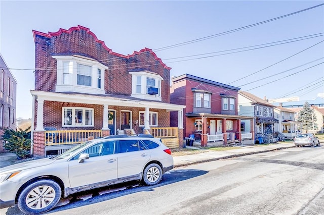 multi unit property with brick siding and a porch