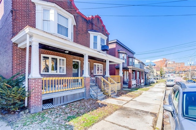 view of front of property featuring a porch and brick siding