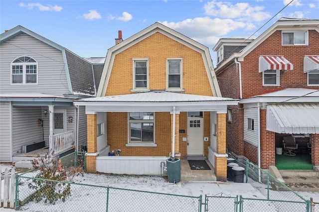 view of front of house with brick siding, a fenced front yard, a gambrel roof, and central air condition unit