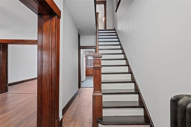 staircase with baseboards and wood finished floors